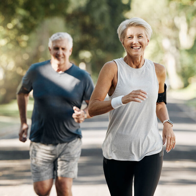 Mann und Frau laufen sportlich im Park